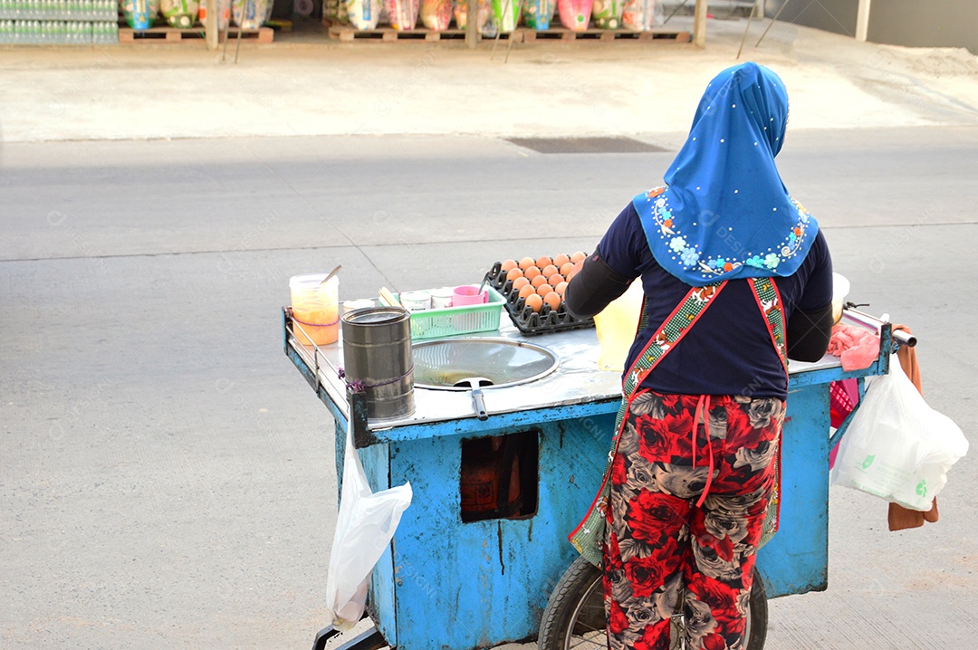Mulher com carrinho de comida de rua