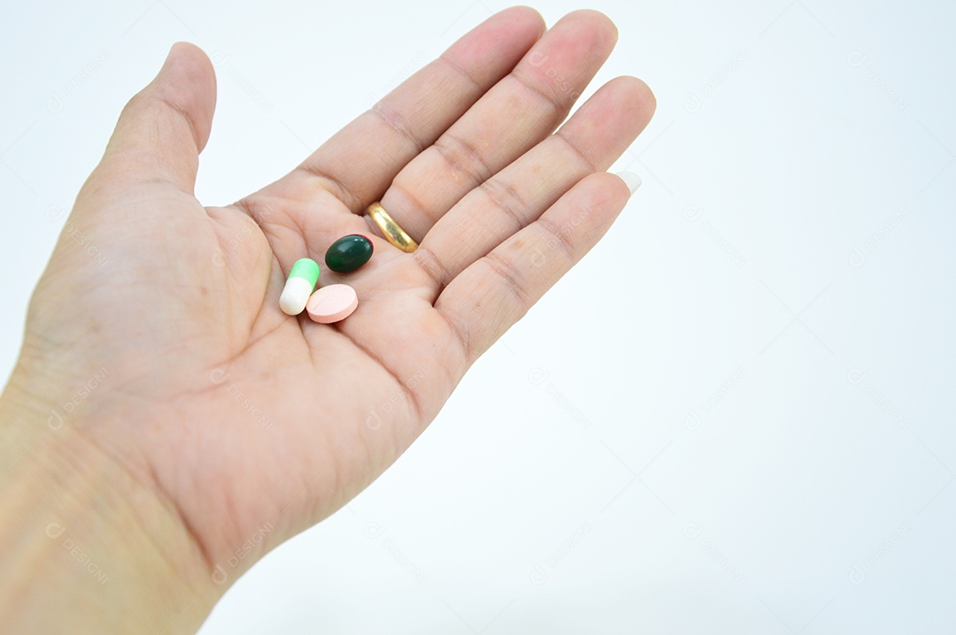 Mãos segurando comprimidos em fundo branco