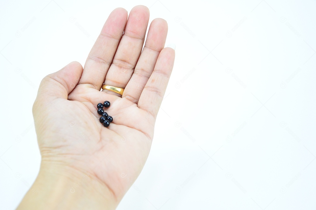Mãos segurando comprimidos em fundo branco