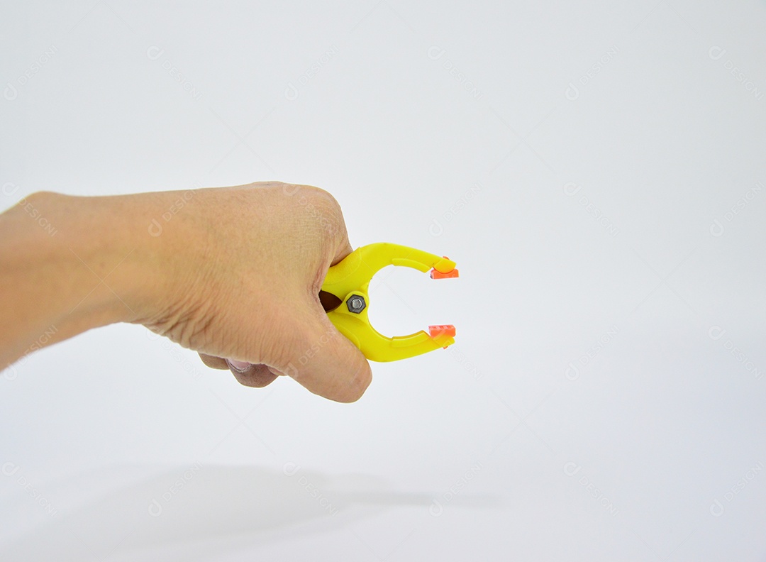 Mão segurando grampo amarelo de multiuso