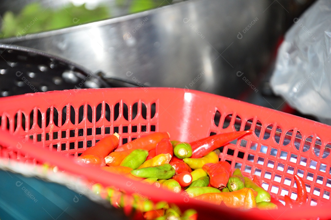 Cesta vermelha com pimentas vermelhas e verdes