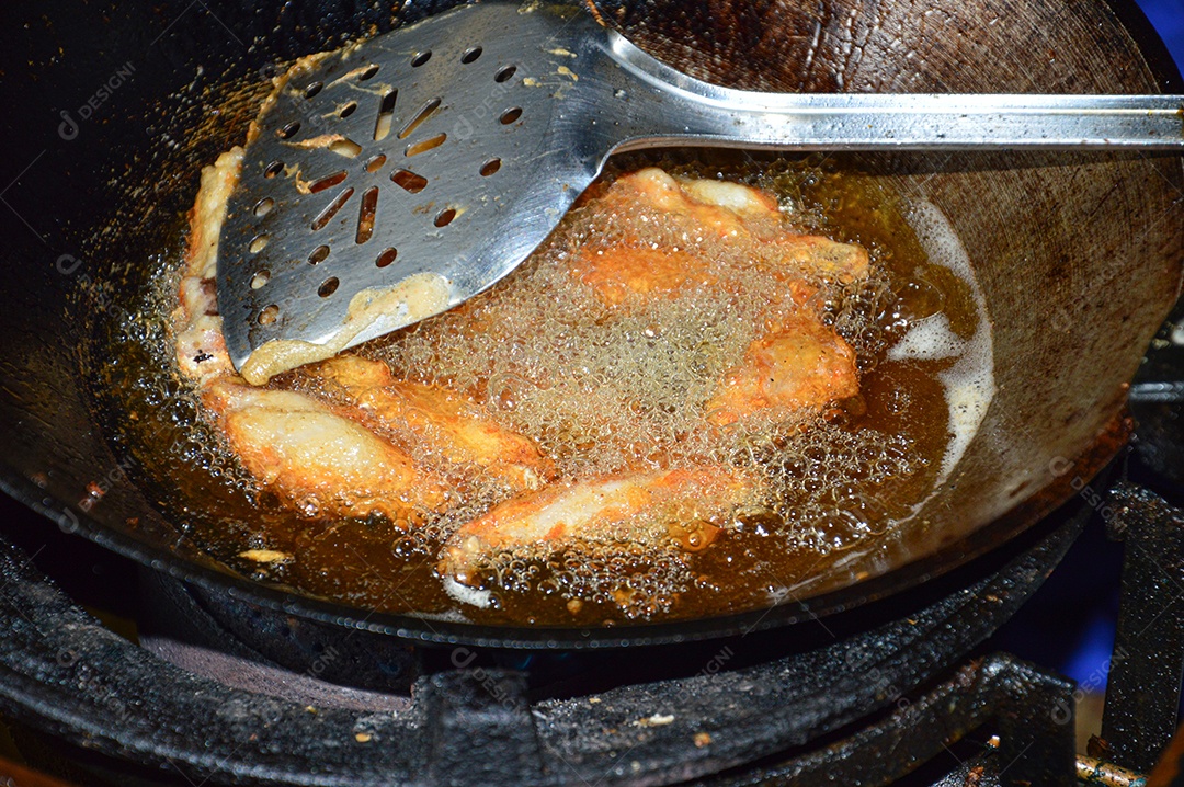 Panela com tulipas de frango sendo fritas