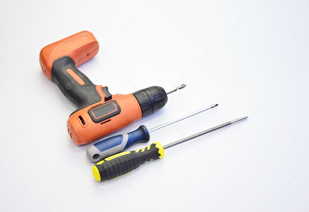 Furadeira elétrica e chaves de fenda em fundo branco