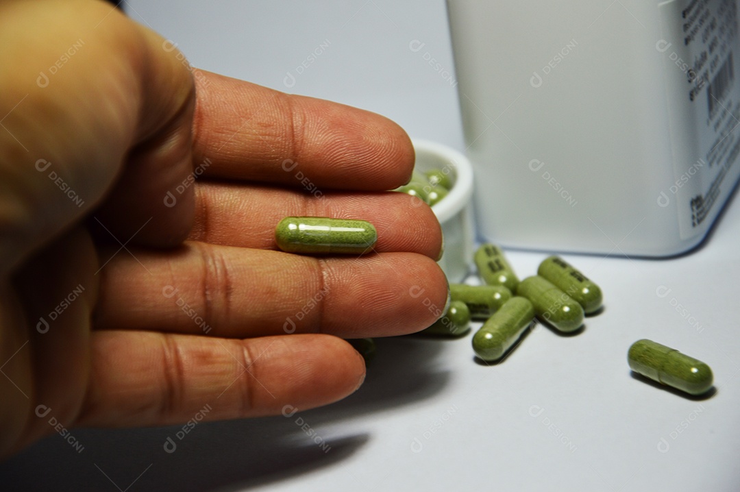 Homem segurando cápsulas de remédio