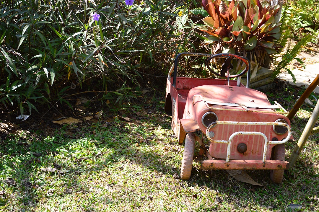 Carrinho velho vermelho sobre quintal