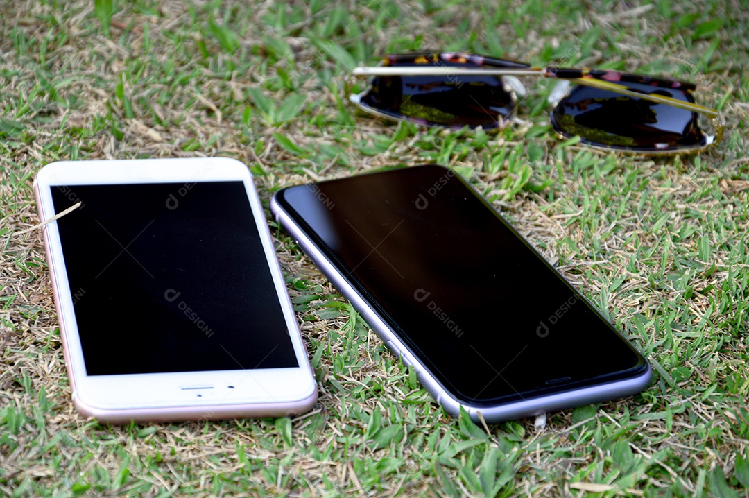 Celulares sobre o gramado verde