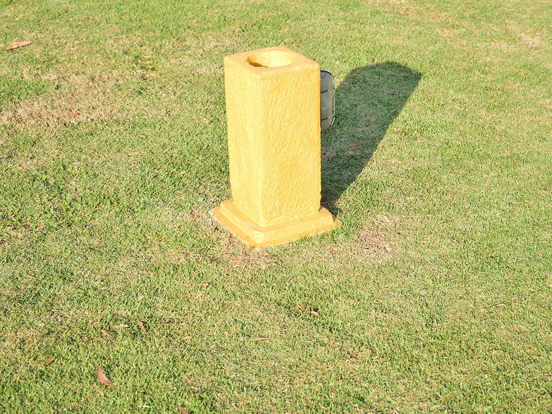 Vaso amarelo de concreto sobre gramado