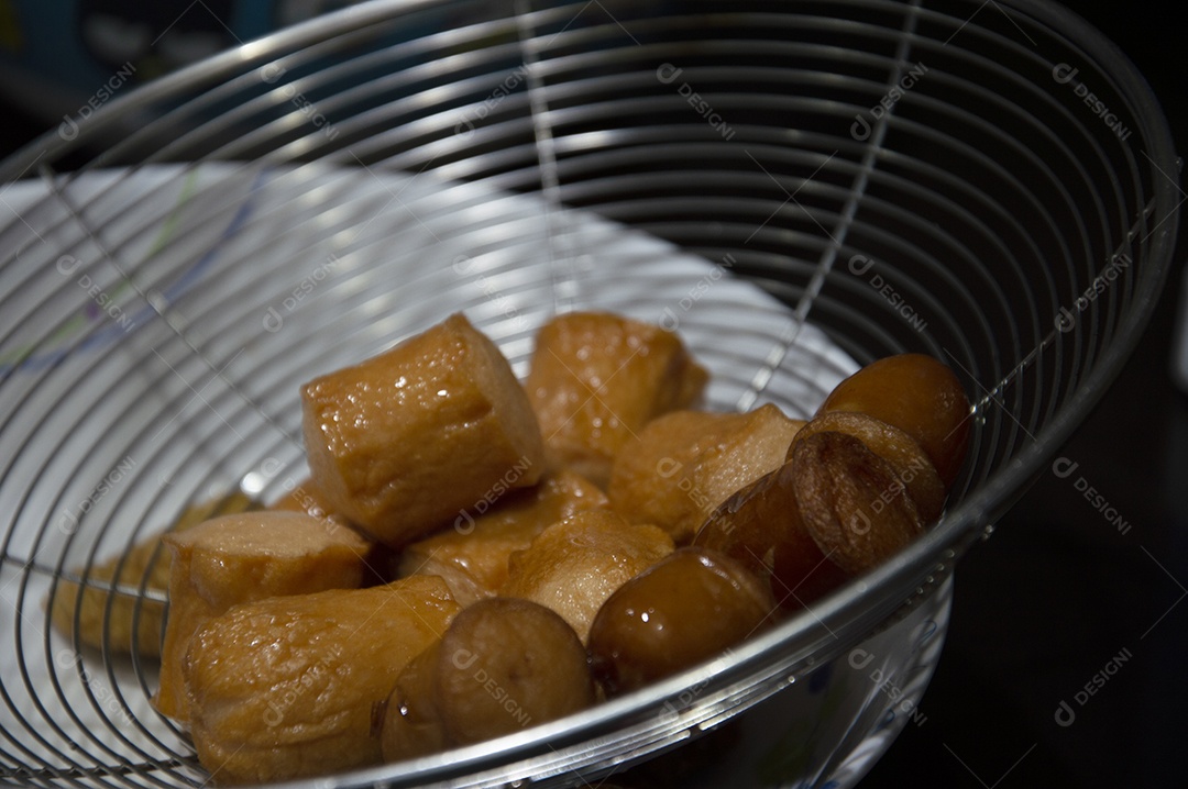 Salsichas fritas sobre escorredor