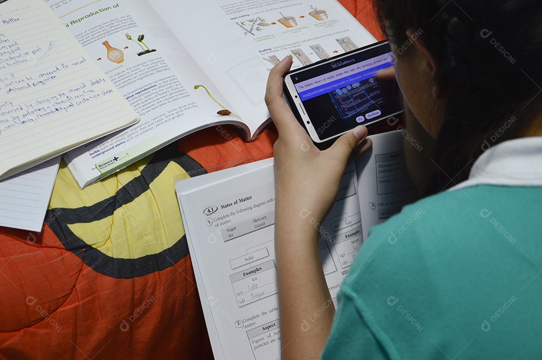 Menina fazendo tarefas da escola consultando celular