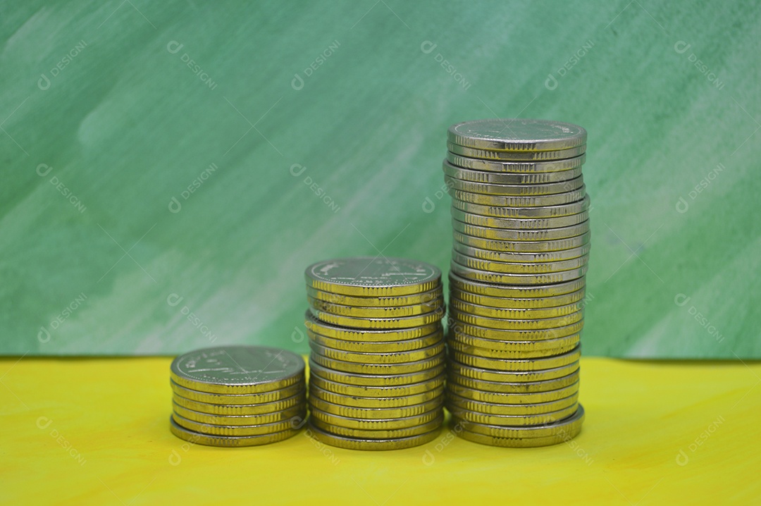Moedas empilhadas em fundo verde