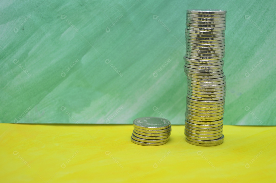 Moedas empilhadas em fundo verde