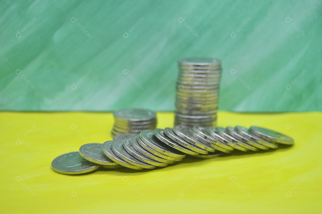 Moedas empilhadas em fundo verde
