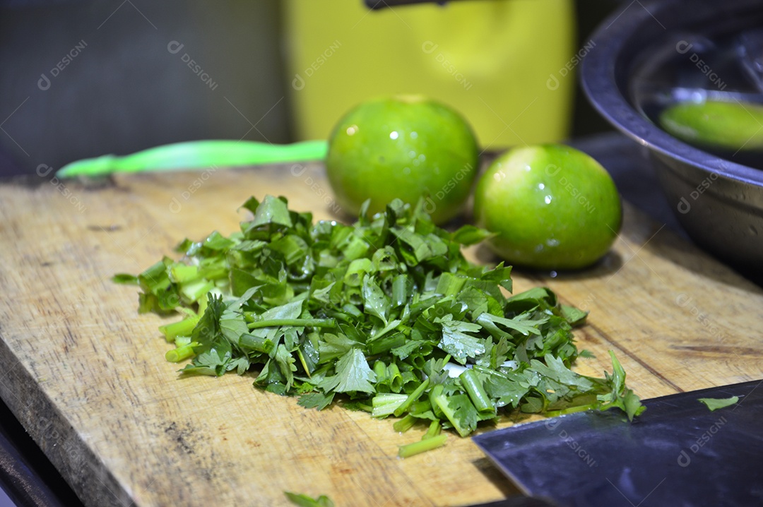Cheiro verde picado em tábua de madeira