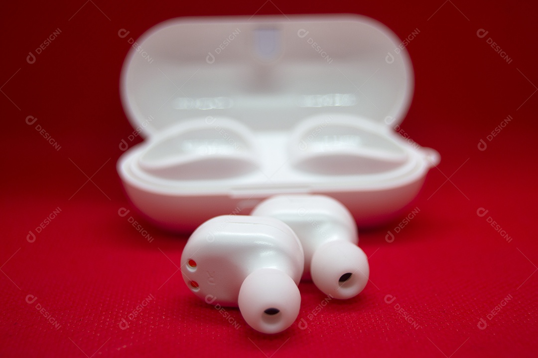 Fones de ouvido sem fio brancos isolados do fundo vermelho