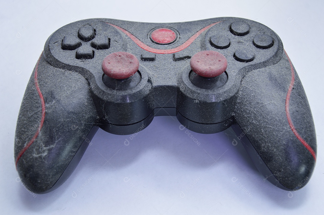 Controle de vídeo game usado para jogar. Está em estado muito antigo e com muita poeira.