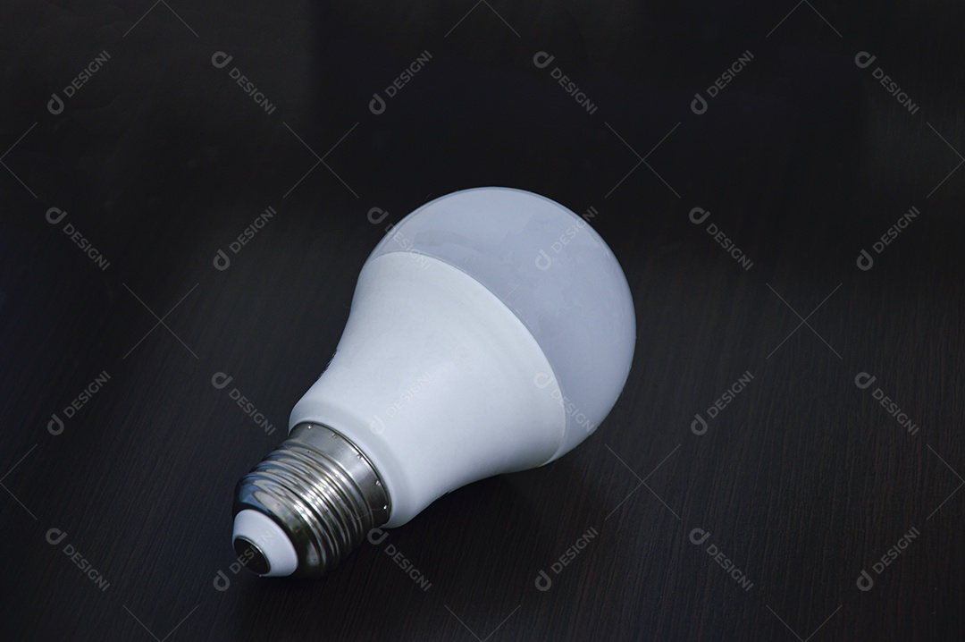 Lâmpada branca vazia no chão de madeira preto.