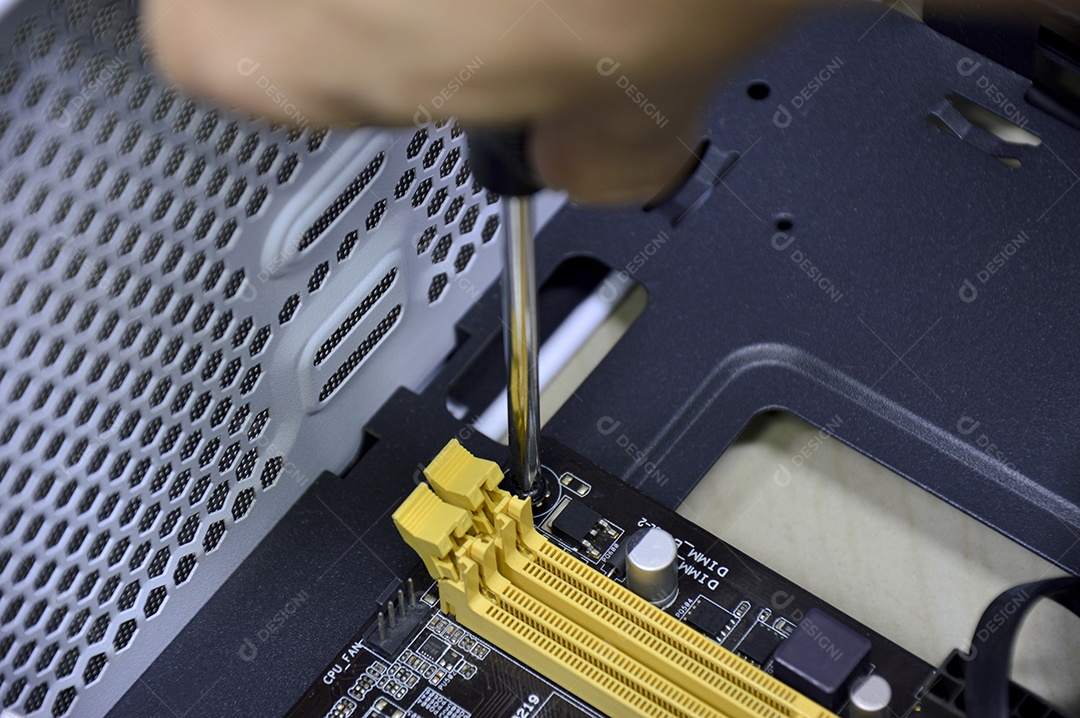 Foto durante a montagem um canto da placa-mãe, apertando os parafusos.