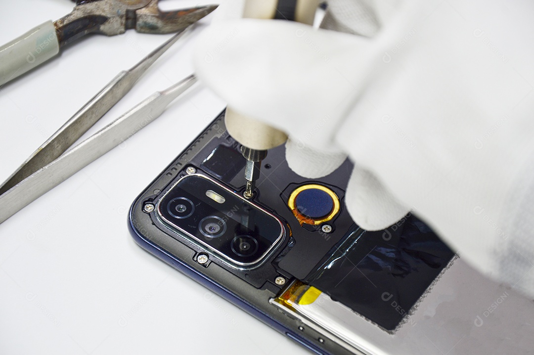 Imagem de um técnico enroscando a parte traseira de um celular.