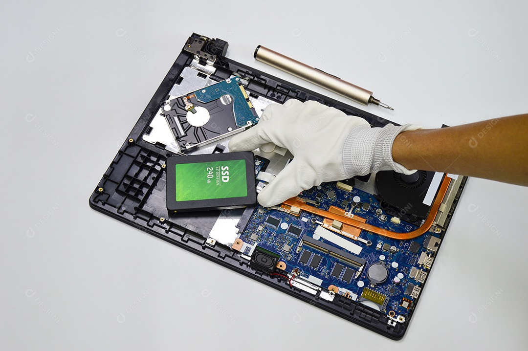 Vista superior enquanto o mecânico repara a placa-mãe (disco rígido, SSD)