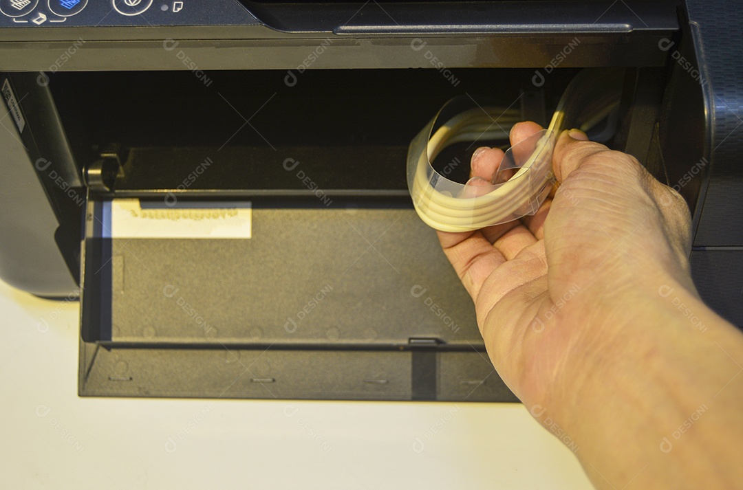 A imagem segura a linha de fornecimento de tinta da impressora.