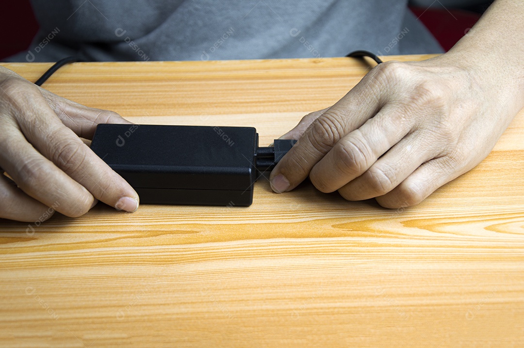 Homem conectando a um adaptador de energia preto