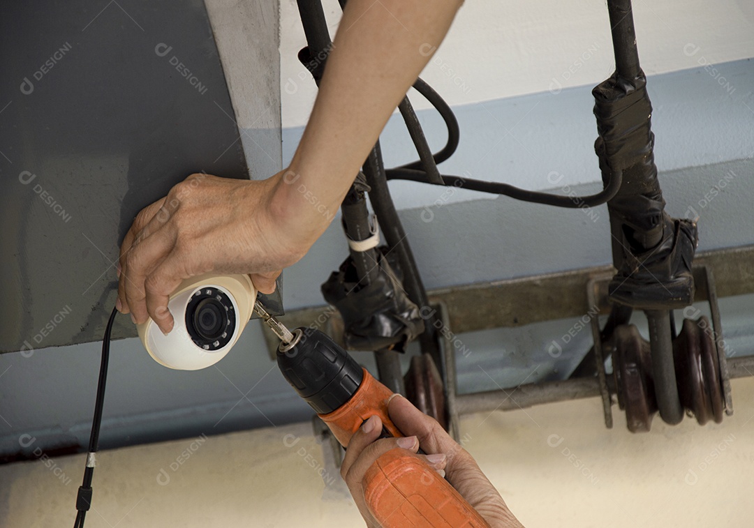 Técnico instalando câmera em uma parede