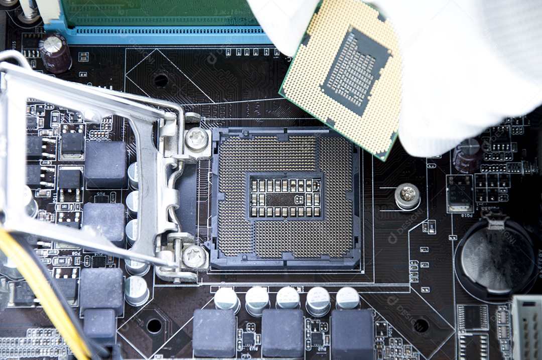 Vista superior da placa mãe e do técnico prestes a inserir o chip da CPU
