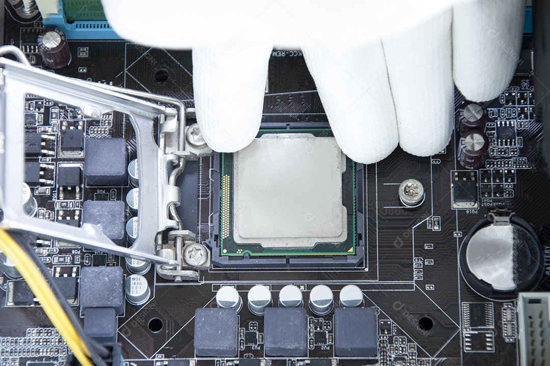 Vista superior da placa mãe e do técnico prestes a inserir o chip da CPU