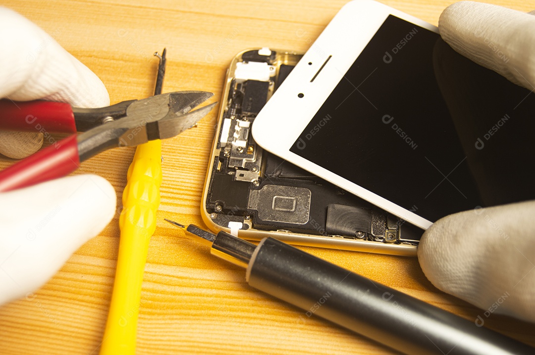 Vista superior de um técnico reparando um smartphone