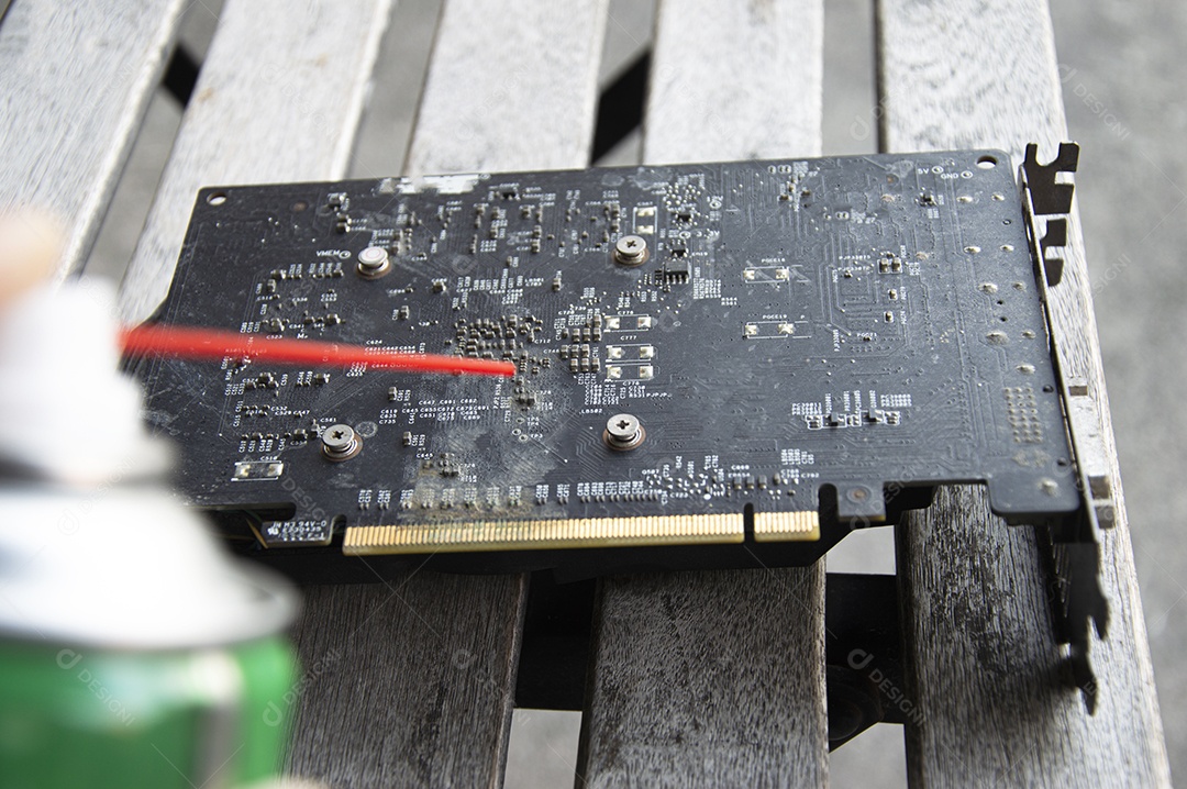 Vista do técnico usando spray para limpar a placa gráfica