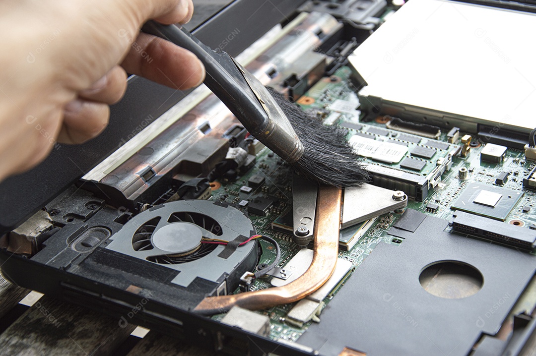 Técnico usando escova Limpe o notebook empoeirado