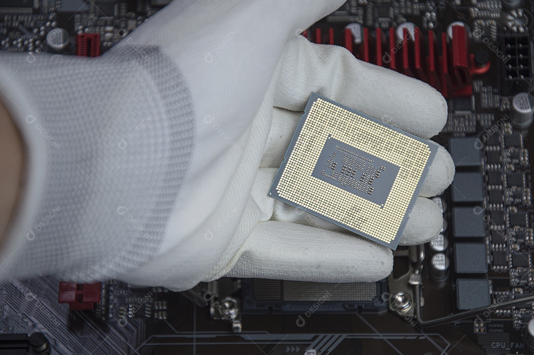 Vista superior da placa mãe e do técnico prestes a inserir o chip da CPU