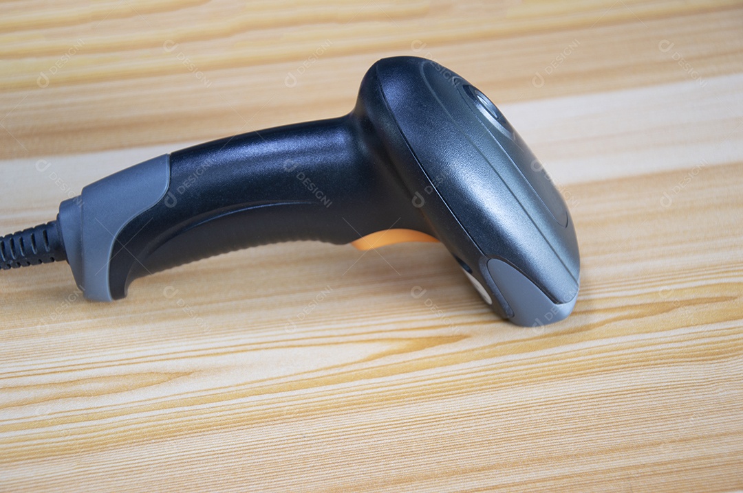 Scanner de código de barras colocado sobre a mesa de madeira marrom