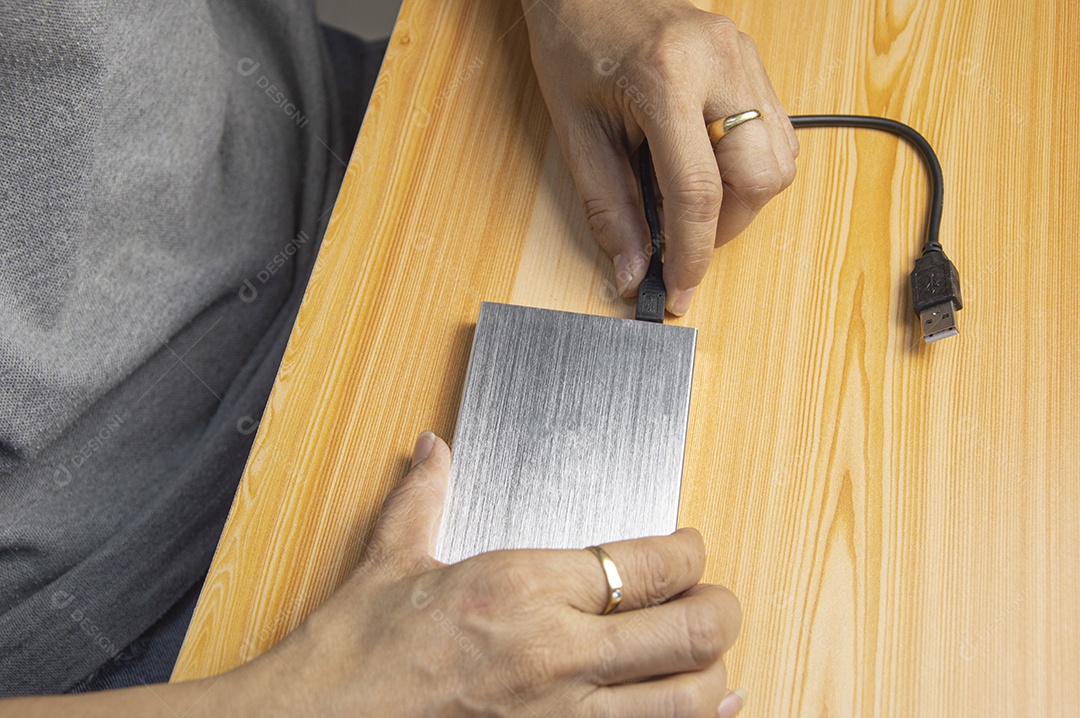 Homem conectando o cabo USB do disco rígido externo