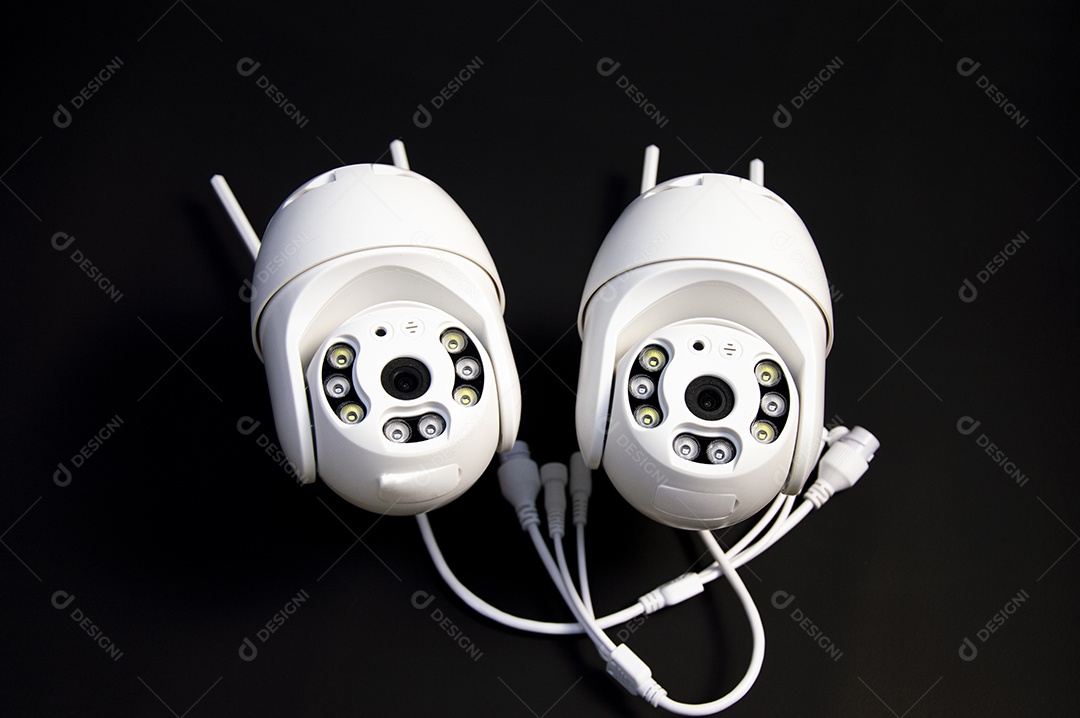 Duas câmeras IP brancas colocadas sobre um fundo preto