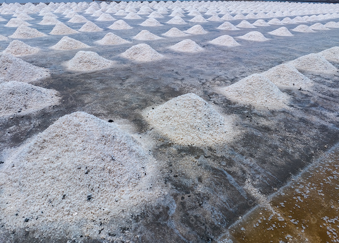 Fazenda de sal marinho. Pilha de salmoura. Matéria-prima do sal industrial. Cloreto de sódio mineral.