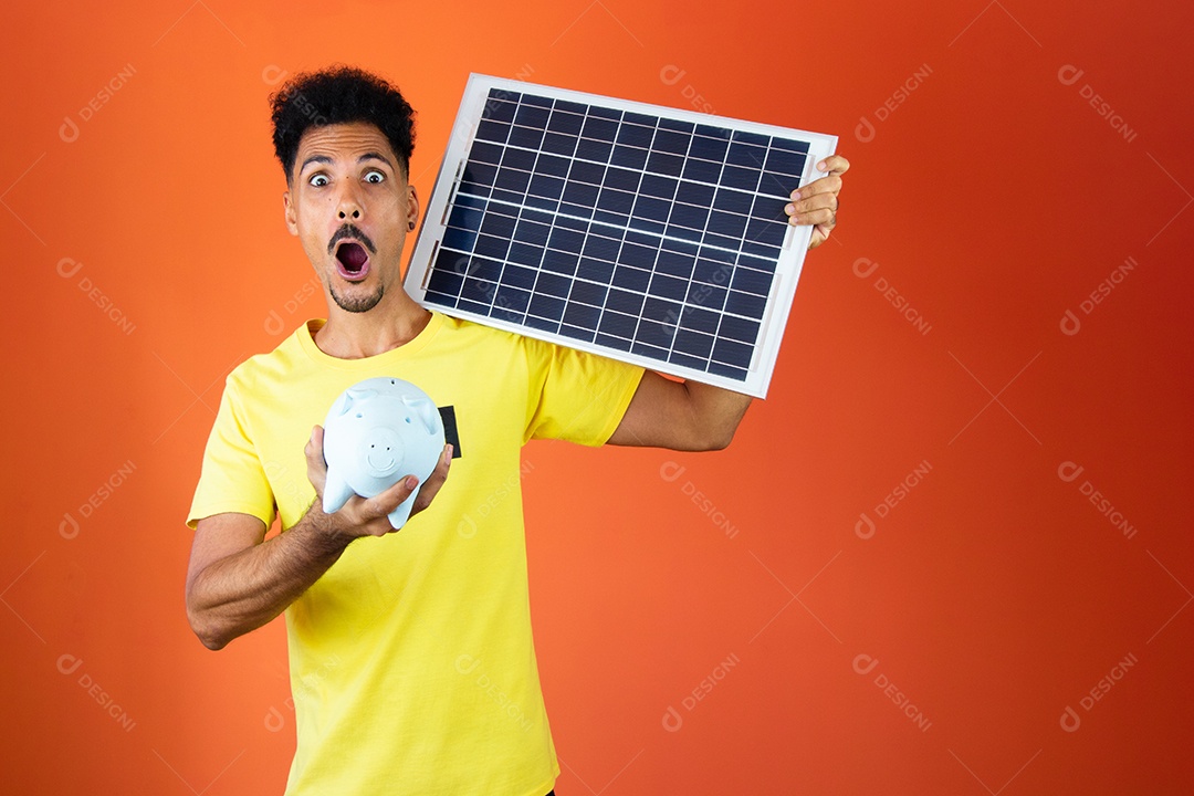Homem negro segurando um cofrinho e painel solar isolado em laranja.