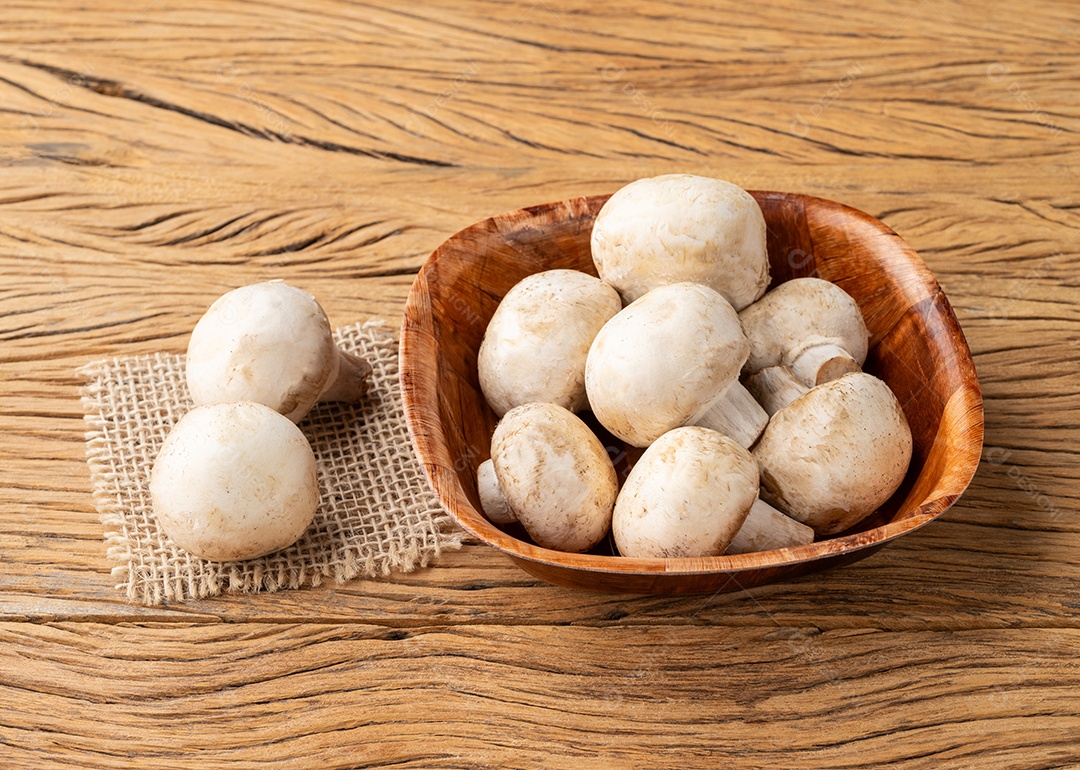 Cogumelos Paris em uma tigela sobre a mesa de madeira