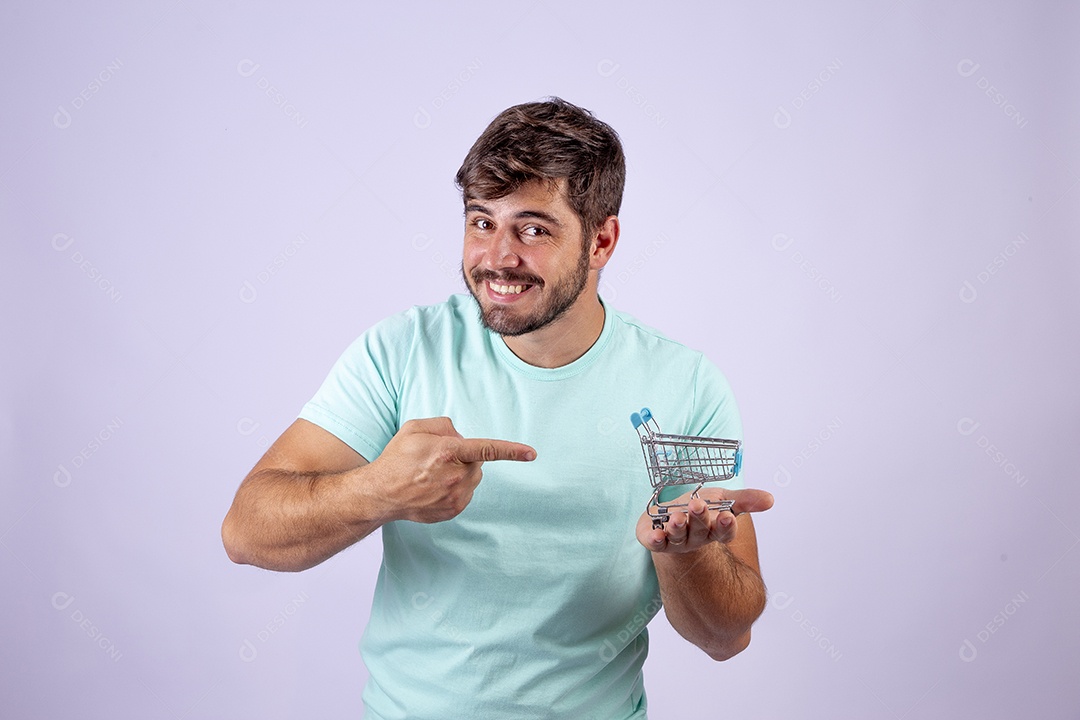 Lindo homem jovem sorridente segurando carrinho de compras