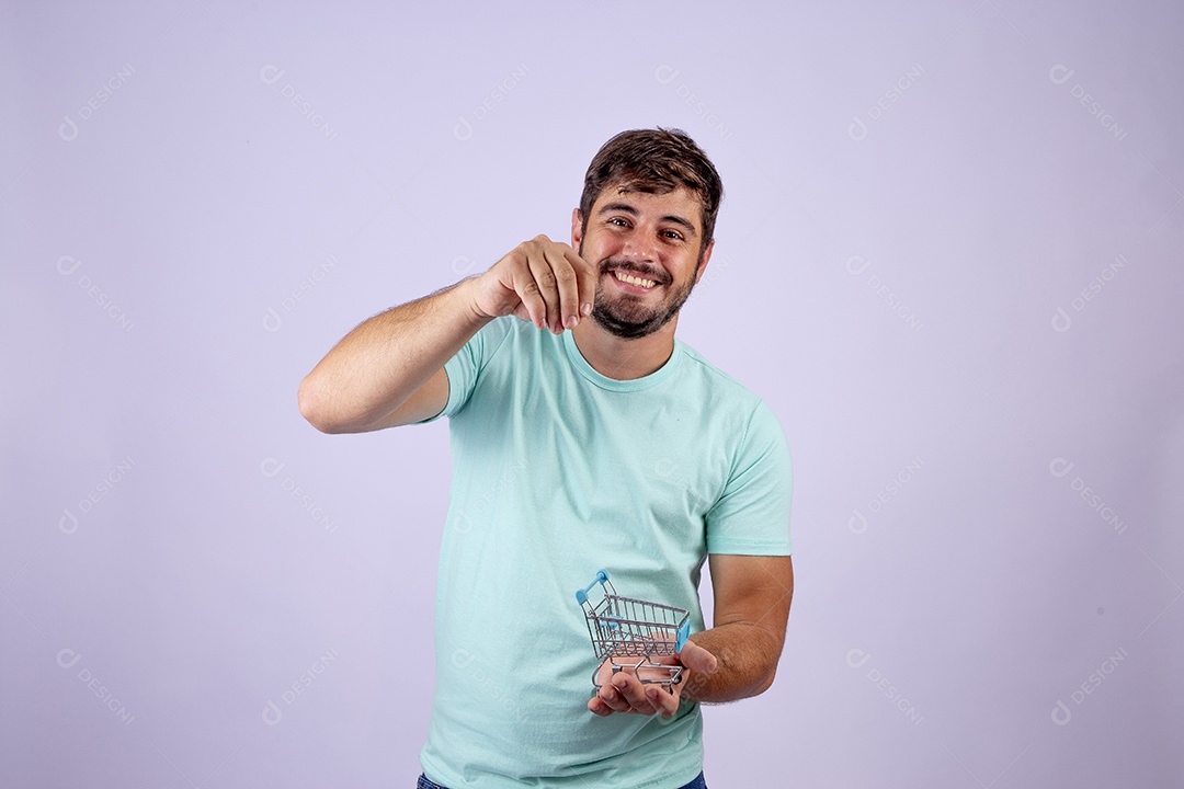 Lindo homem jovem sorridente segurando carrinho de compras