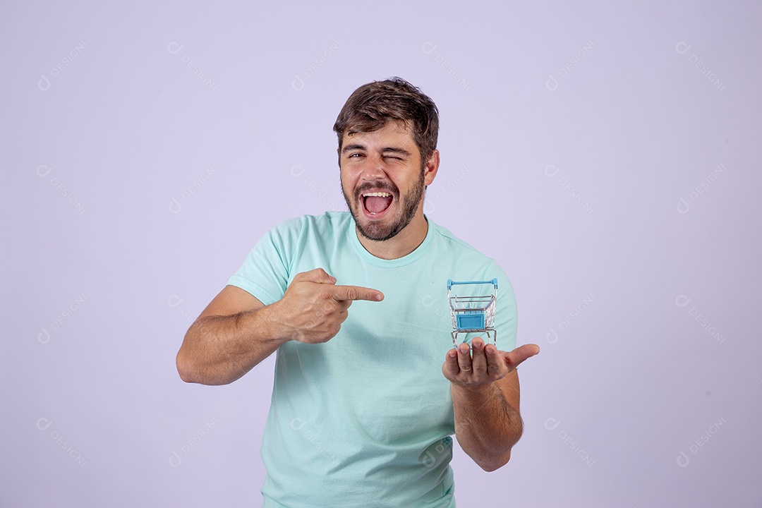 Lindo homem jovem sorridente segurando carrinho de compras