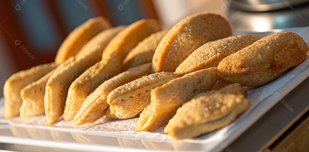 Café da manhã farto servido com bolos, tortas, geléias, doces, queijos, presunto, café, leite.