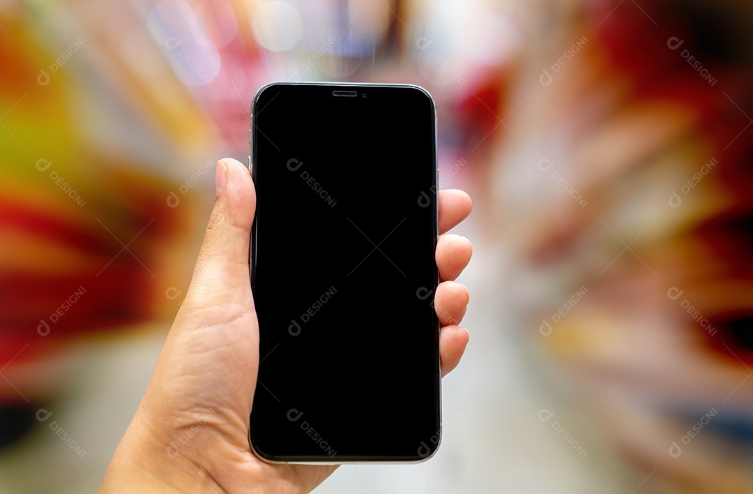 Mão segurando smartphone maquete preto e fundo desfocado com bokeh