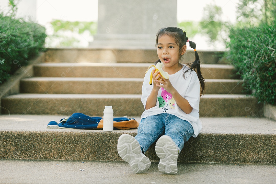 Garotinha sentada comendo lanche saudável