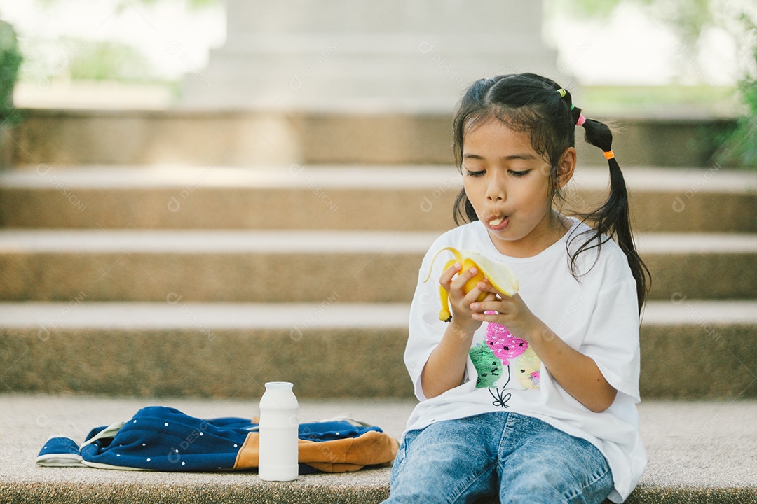 Garotinha sentada comendo lanche saudável