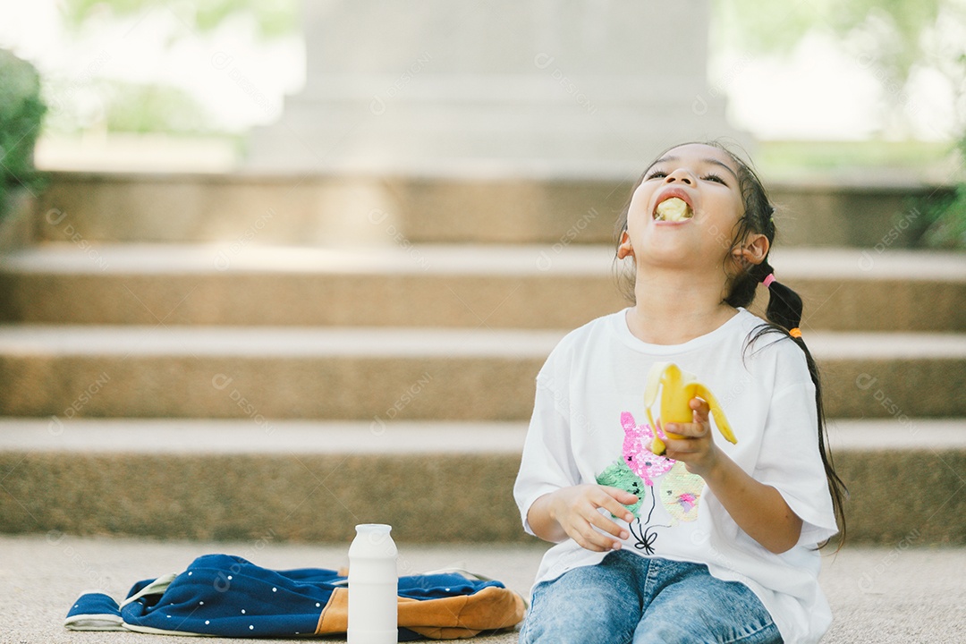 Garotinha sentada comendo lanche saudável