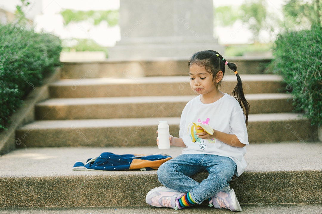 Garotinha sentada comendo lanche saudável