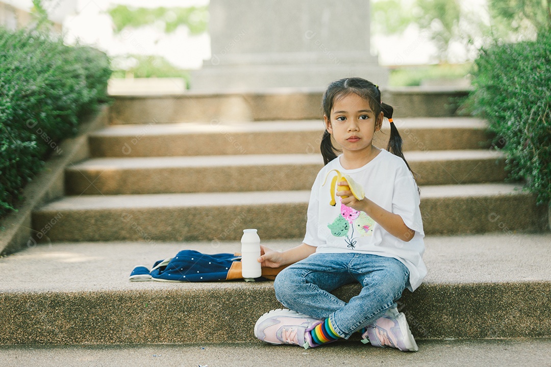 Garotinha sentada comendo lanche saudável