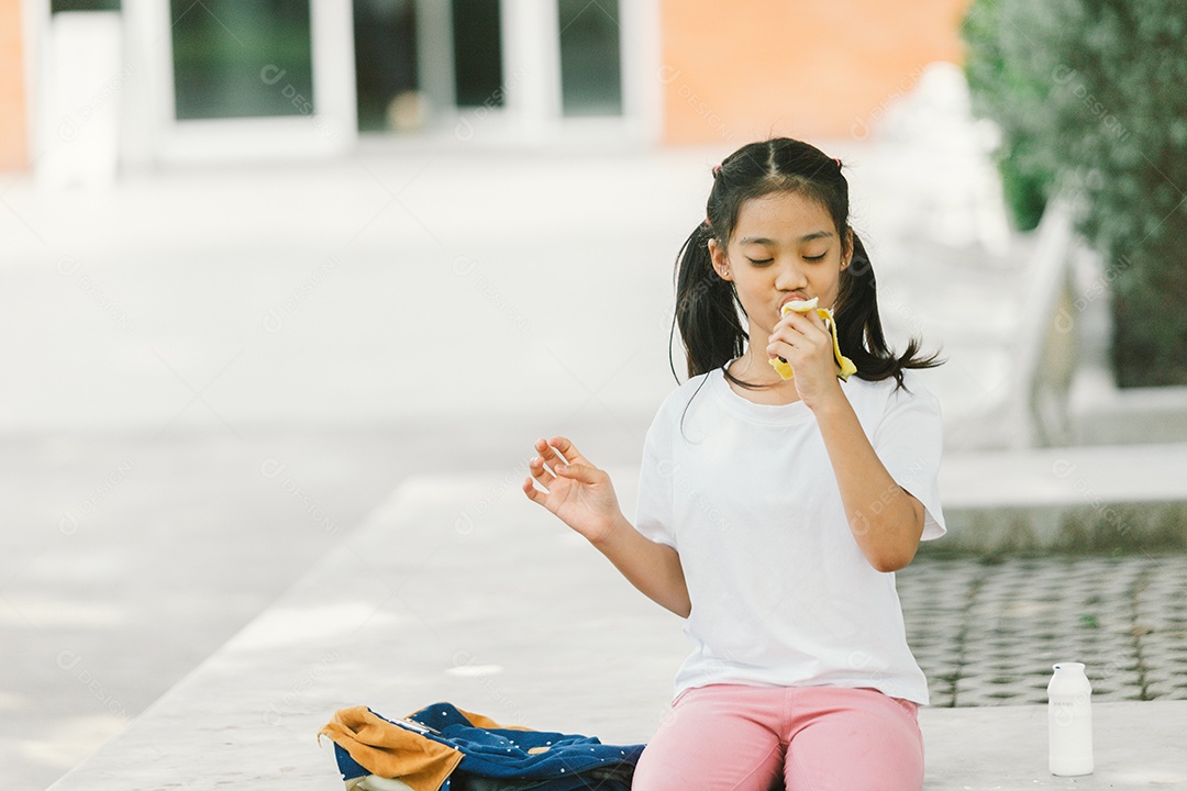 Garotinha sentada comendo lanche saudável
