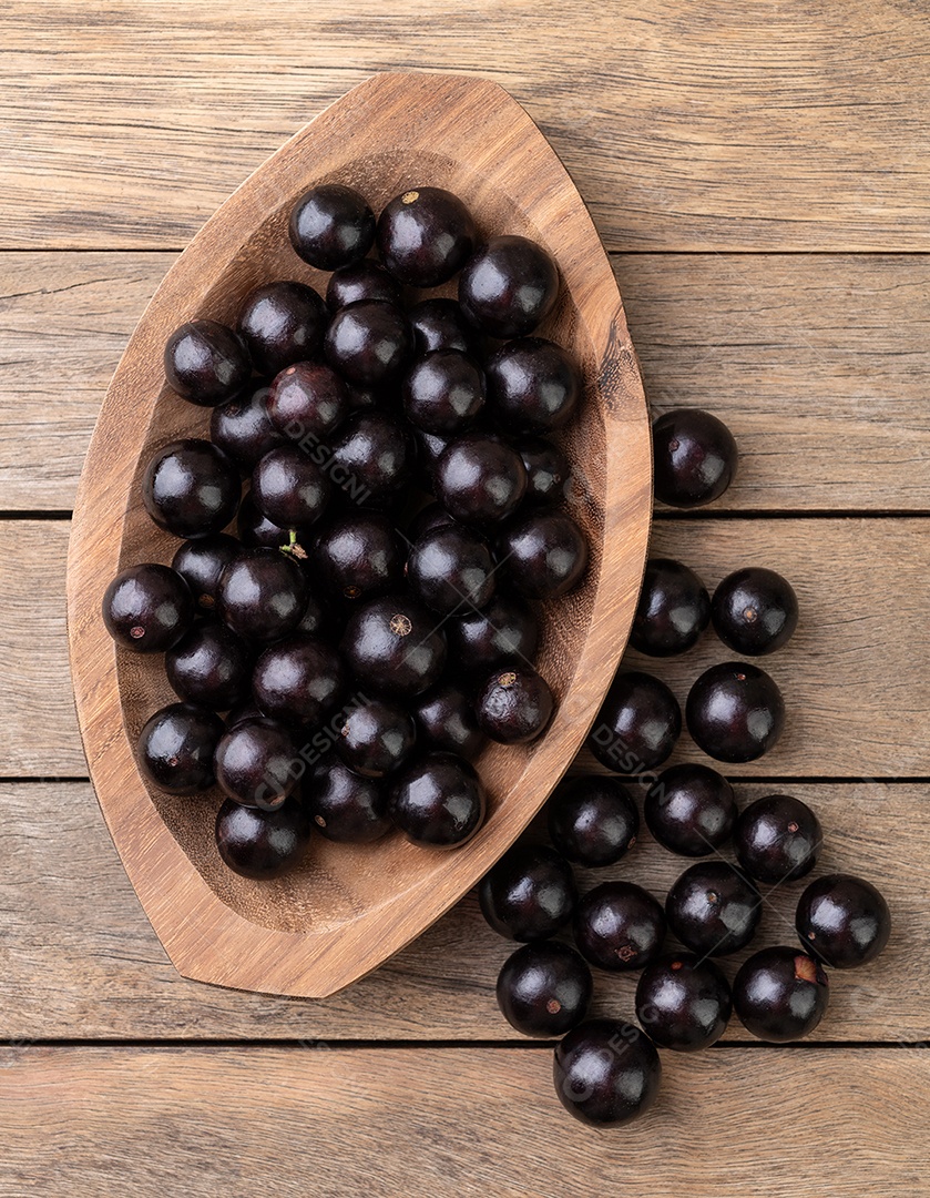 Jabuticabas em uma tigela sobre mesa de madeira.
